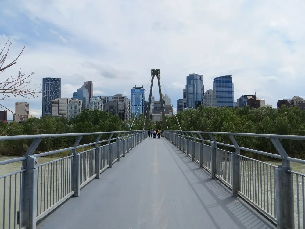 A bridge over the Bow River in front of the Calgary skyline
